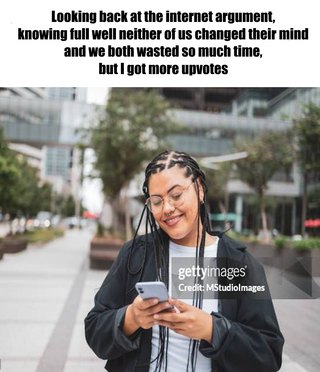 Looking back at the internet argument, knowing full well neither of us changed their minds and we both wasted so much time, but I got more upvotes. Picture of a person smiling at phone, with obvious watermark.