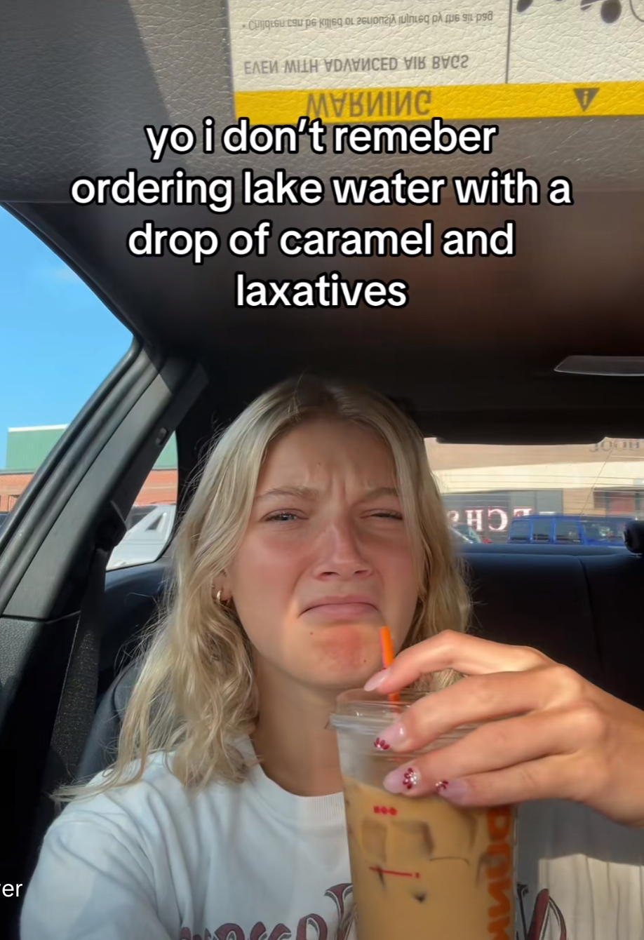 Girl drinking coffee in her car with the caption “yo i don't remeber [sic] ordering lake water with a drop of caramel and laxatives”