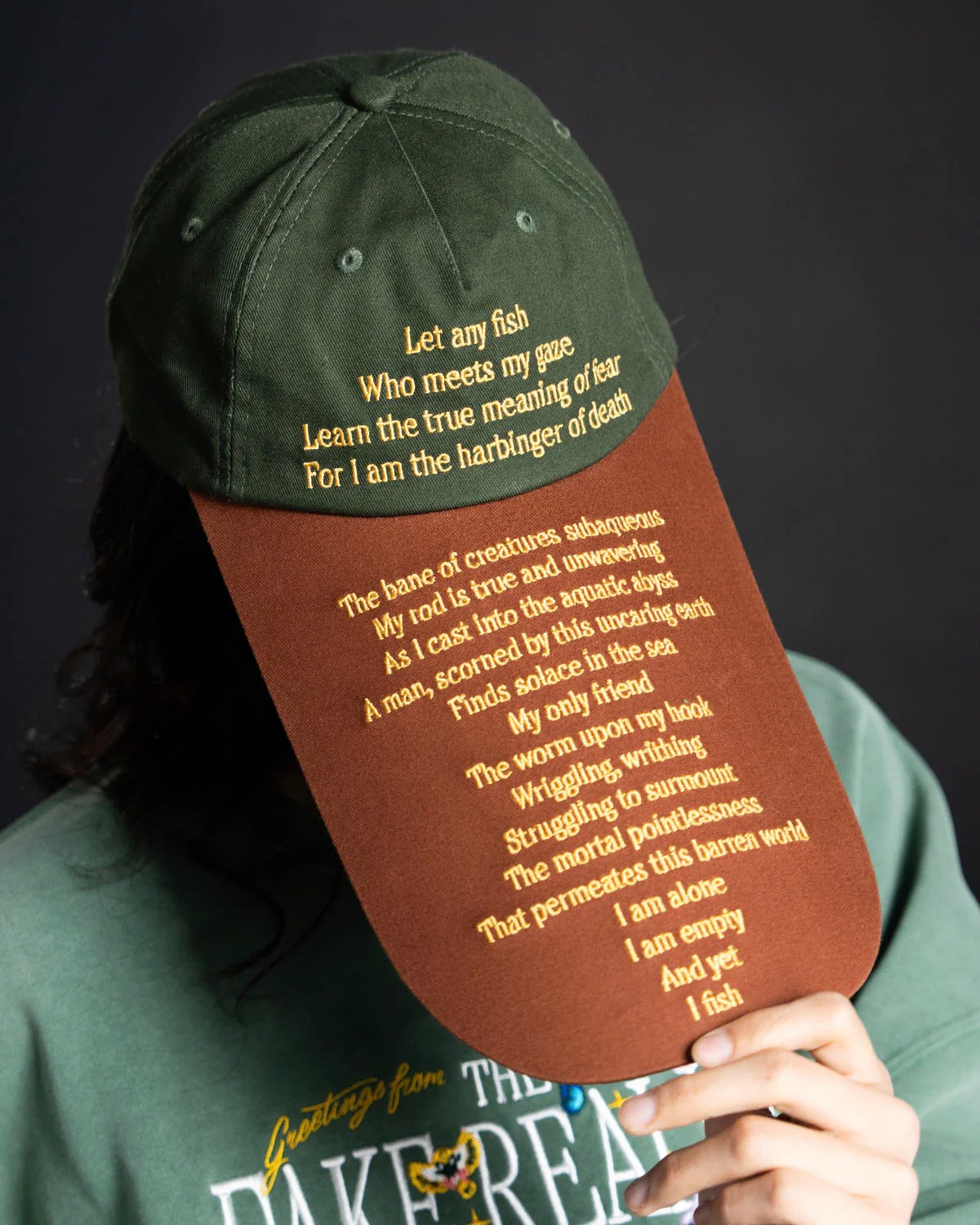 A hat that says: "Let any fish - who meets my gaze - learn the true meaning of fear - for I am the harbringer of death - The bane of creatures subaqueous - My rod is true and unwavering - As I cast into the aquatic abyss - A man, scorned by this uncaring earth - Finds solace in the sea - My only friend - The worm upon my hook - Wriggling, writhing - Struggling to surmount - The mortal pointlessness - That permeates this barren world - I am alone - I am empty - And yet - I fish"